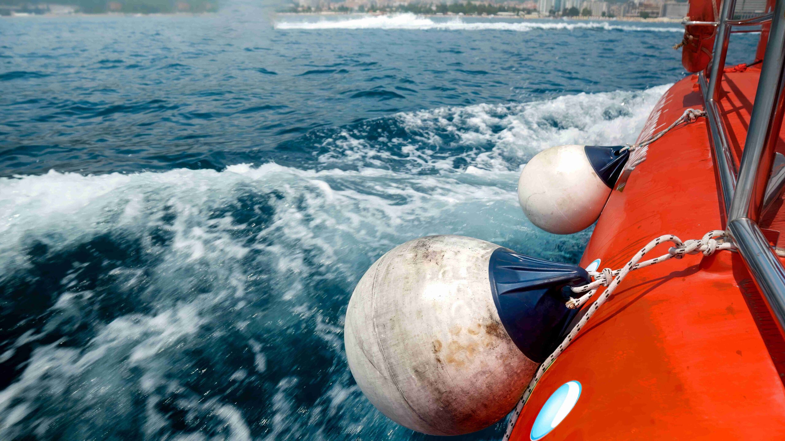 Boat trip on blue ocean with distant city