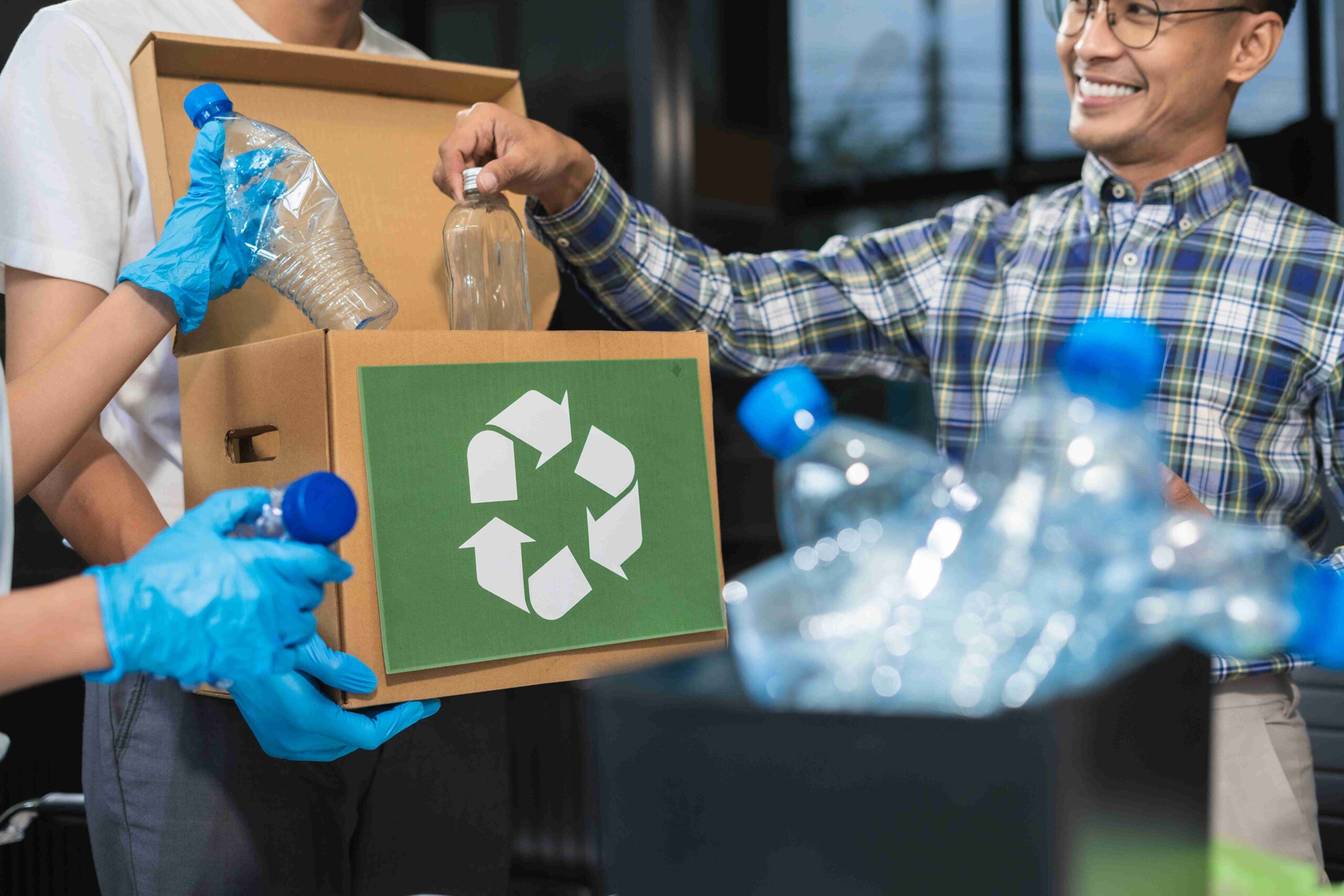 Colleagues recycling bottles at work in an office