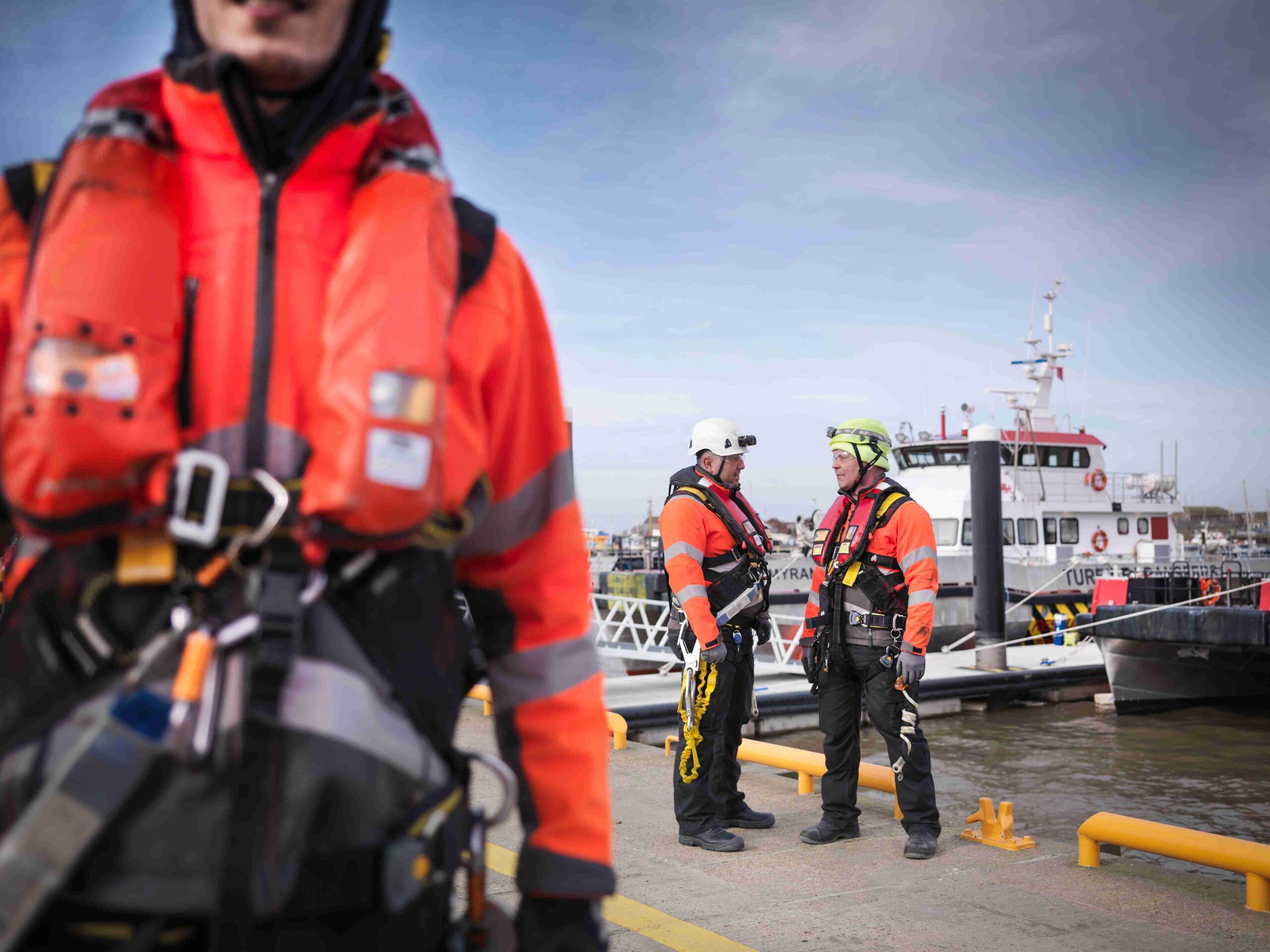 Workers wearing safety gear on the docks